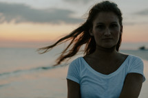 a young woman walking on a beach at sunset 