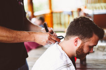 a man getting a haircut at a barbers shop 
