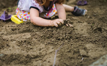 a girl playing in sand 