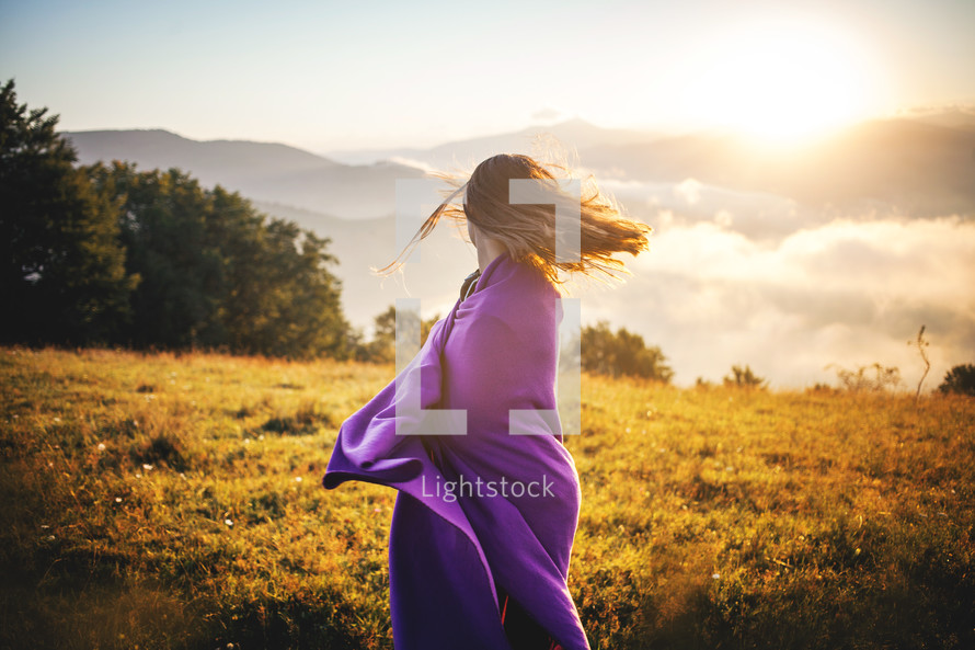 teen girl on a mountaintop wrapped in a blanket 