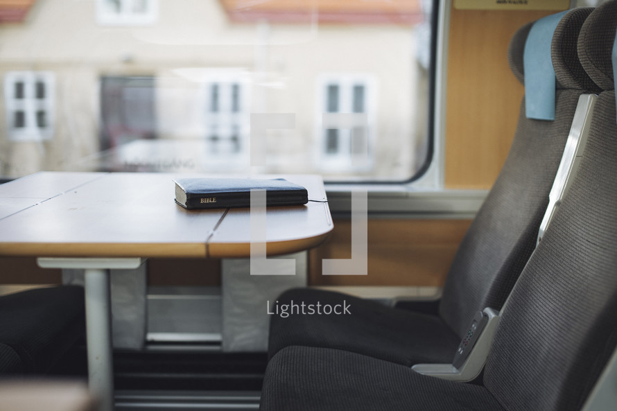 Closed bible laying on a table on a train. 