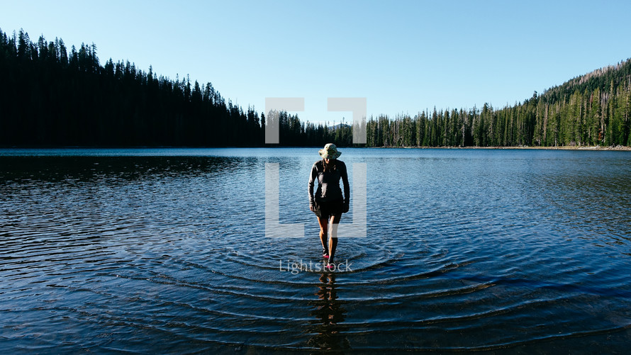 a woman walking through a pond 