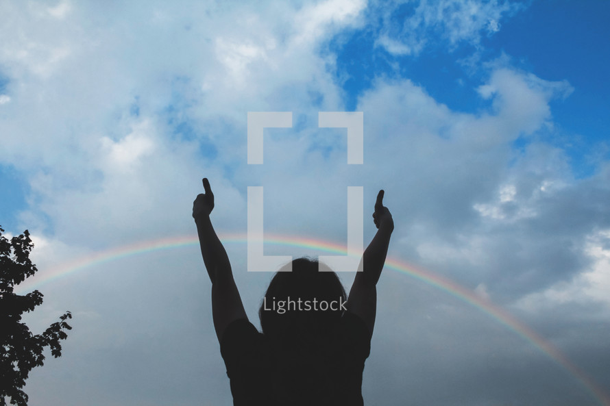 silhouette of a child under a rainbow 