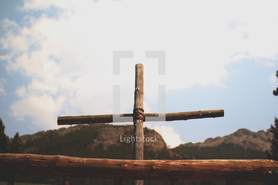 wooden cross with mountains behind it 