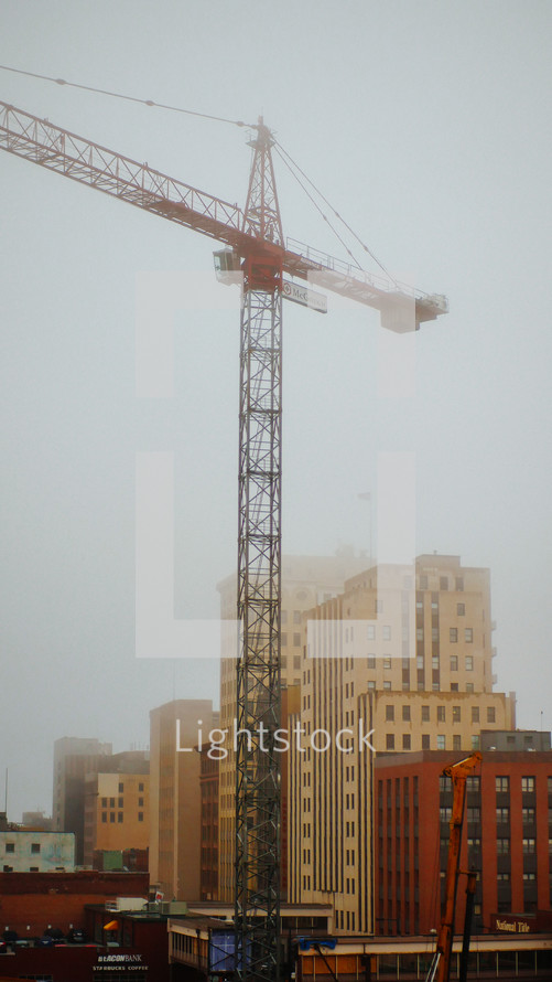 construction crane over a foggy city 