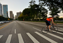 man riding a bike across a city crosswalk