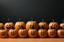 Halloween pumpkins with scary faces on grey background, closeup