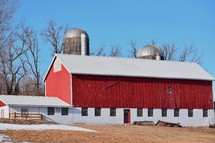 An old red barn with silos on a horsemanship farm in Southwestern Wisconsin.