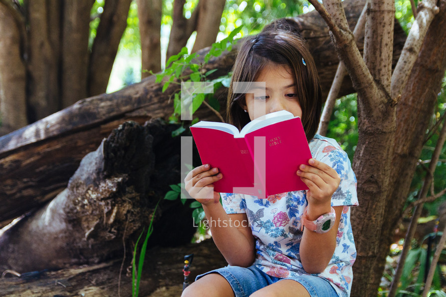 girl child reading outdoors 