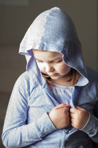 A little girl wearing a lavender hooded sweatshirt.