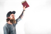 man holding a Bible up praising God 