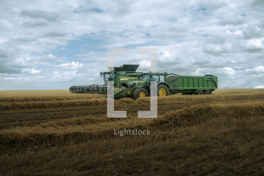Tractor and combine harvester in a field, harvest time farming photo, rural countryside setting, agriculture