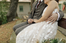  bride and groom sitting on a bench outdoors 