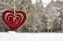 red sparkly heart hanging from a tree 