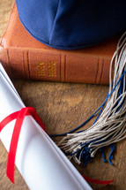 graduation cap and diploma on a Bible 