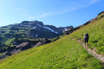 backpacking along a green mountainside 