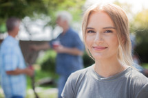 headshot of a young woman at an outdoors summer party 