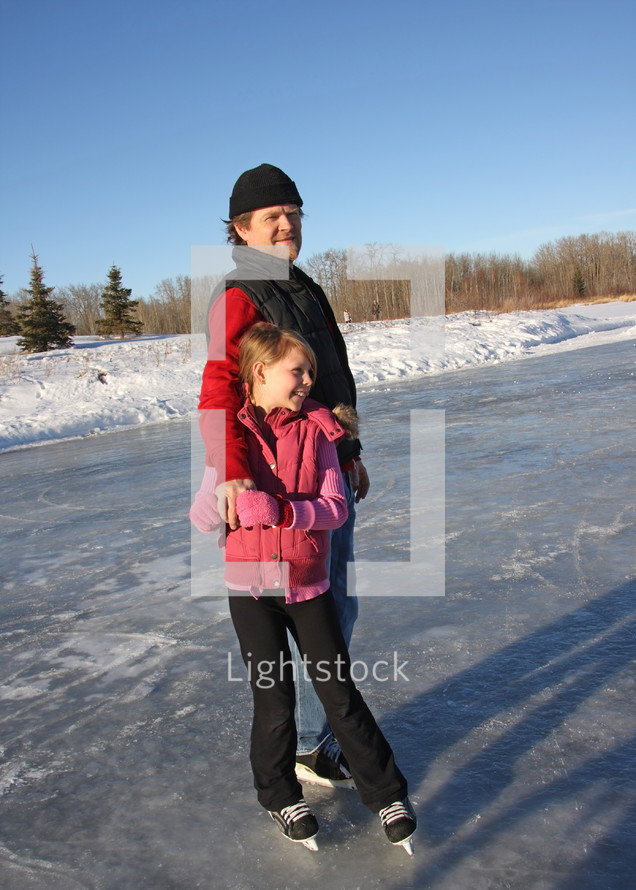 a young daughter and dad skating together