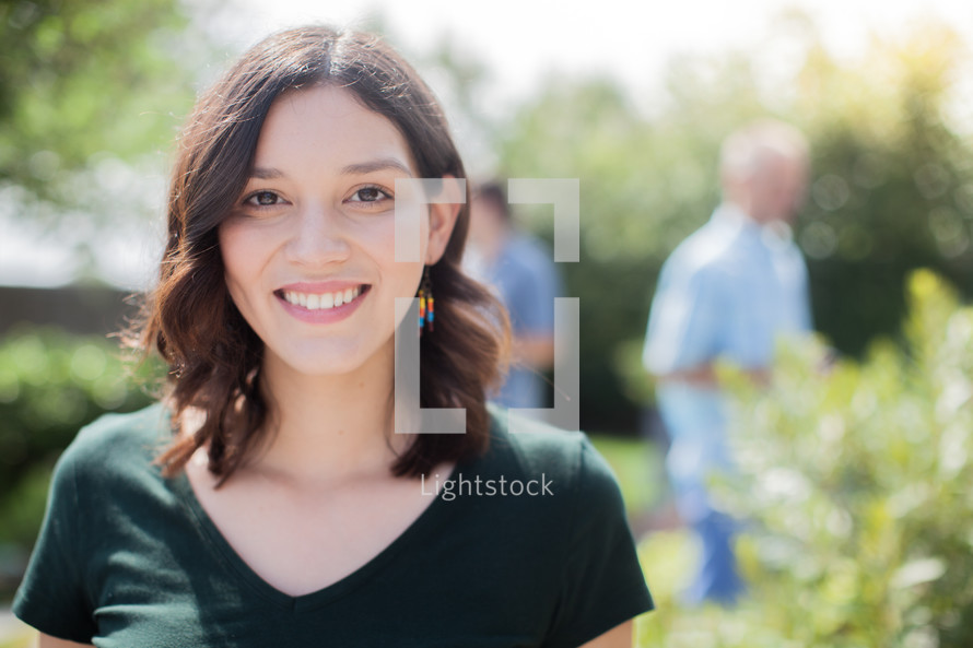 headshot of a young woman at an outdoor summer party 