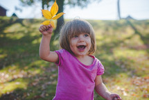 girl holding a fall leaf 