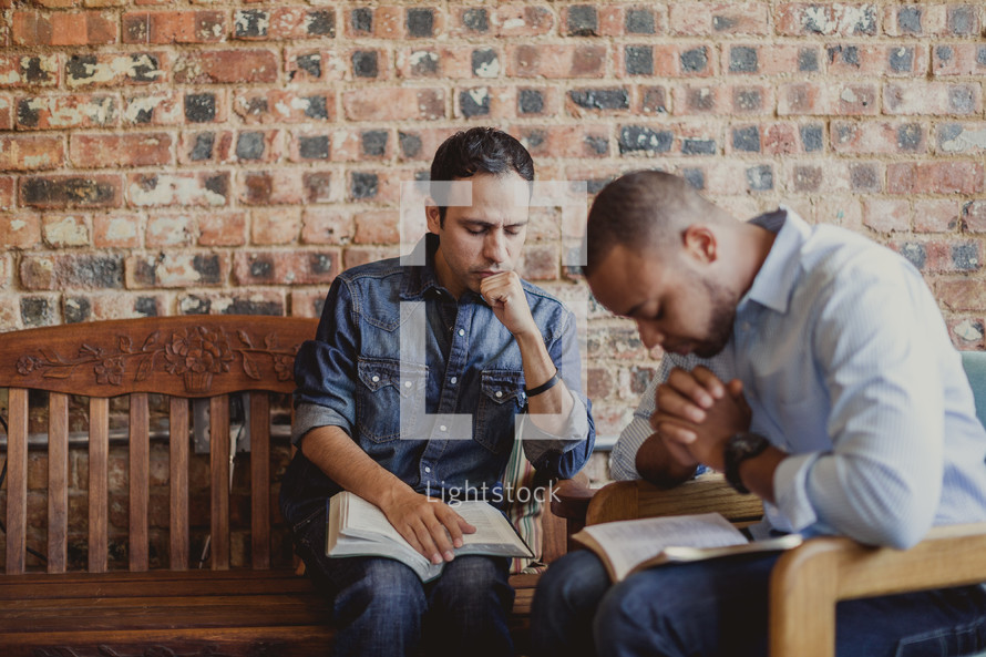 Men praying during a Bible study.