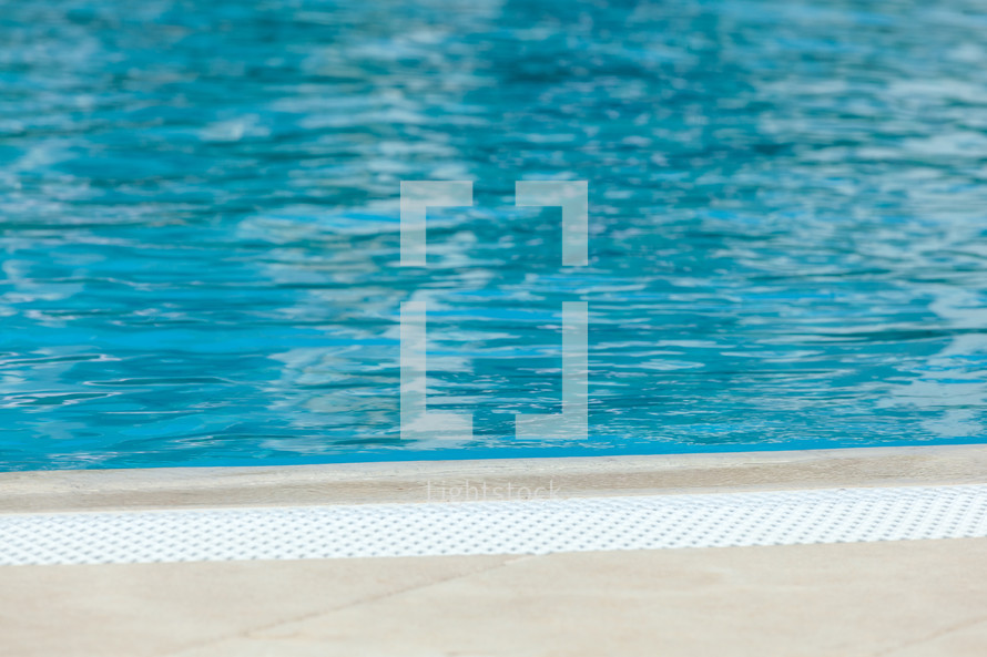 Tranquil blue water surface of swimming pool on sunny day, inviting for a refreshing swim