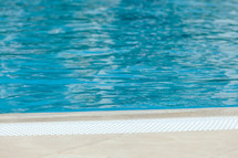 Tranquil blue water surface of swimming pool on sunny day, inviting for a refreshing swim