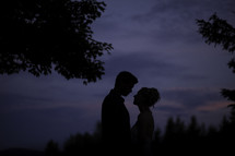 a silhouette of a bride and groom at sunset 