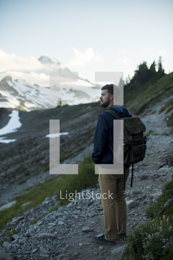 a man backpacking through mountain landscape 