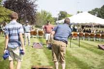 people playing corn hole at a picnic 