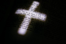 illuminated cross on the pages of a Bible 