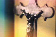 An iron hanging wall sculpture of Jesus Christ on the cross.