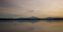distant snow capped mountains across a lake 
