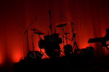 drum set on stage in front of red stage curtains