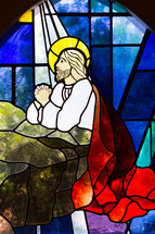 stained glass window of Jesus kneeling in prayer 