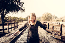 woman walking on railroad tracks 