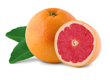Sliced grapefruit half with a whole grapefruit on leaves.