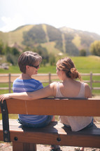 mother and daughter in conversation on a park bench 