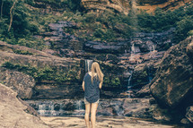 woman looking at a trickling waterfall 