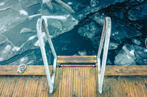 a ladder on dock over a frozen lake 
