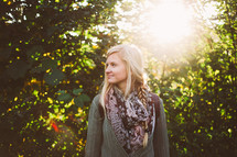 blonde woman standing outdoors and a burst of sunlight 