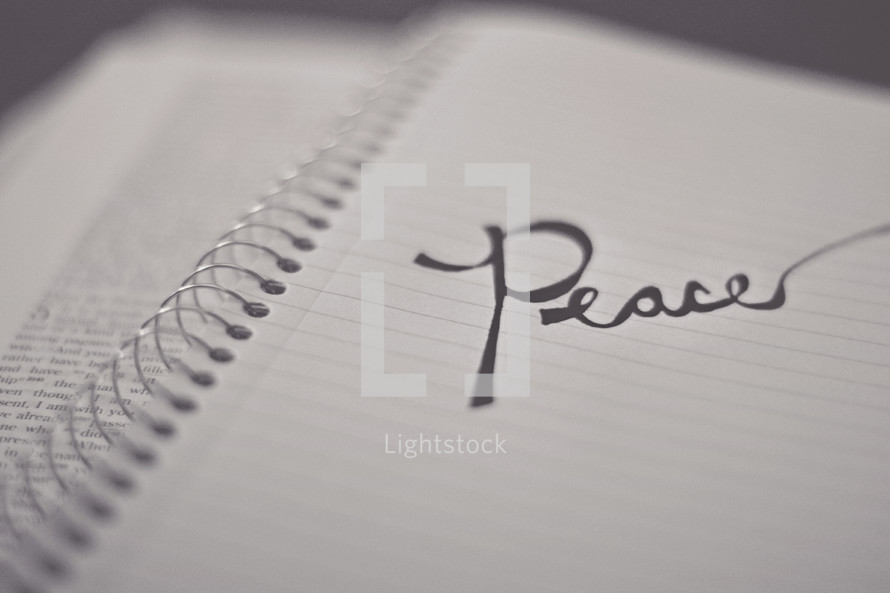 word Peace on a notebook on the pages of a Bible 