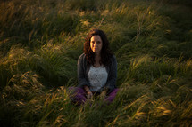 woman sitting in a field of green grass