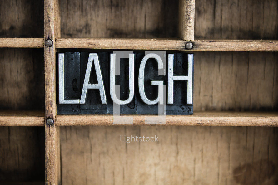 word laugh in blocks on a bookshelf 