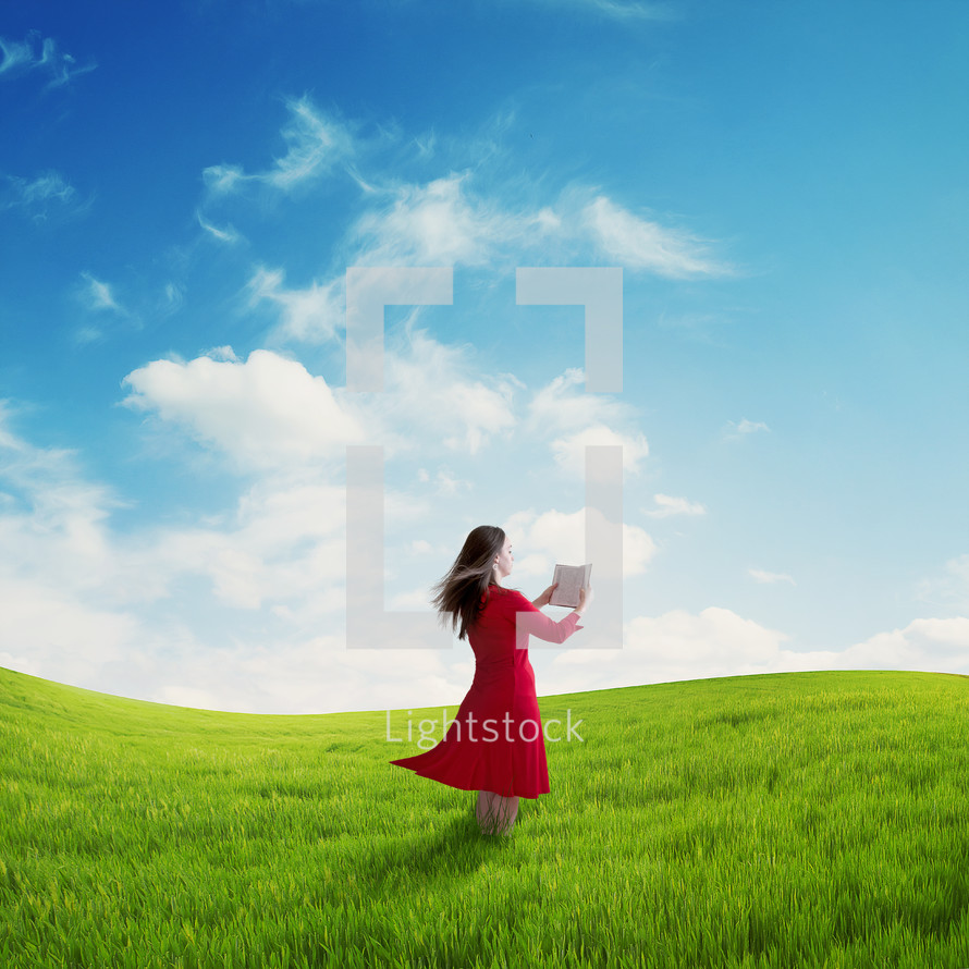 woman reading in an open field 