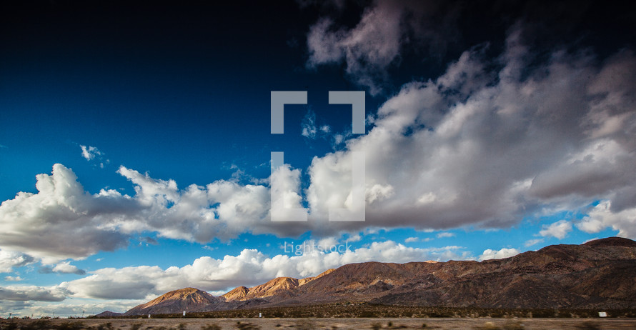 clouds and a cobalt blue sky over mountains in Nevada 