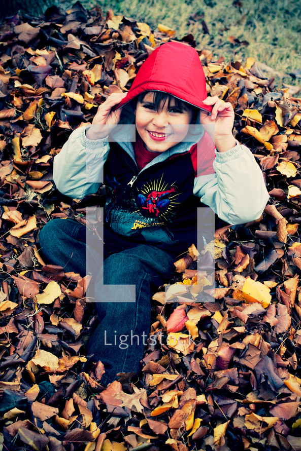boy child playing in leaves