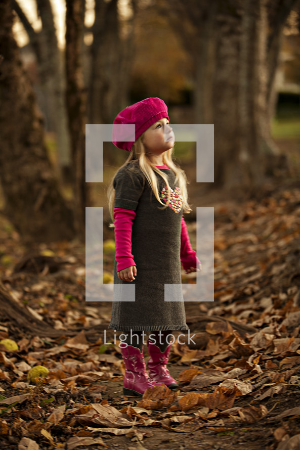 girl stand amid leaves 