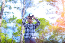 a man in a forest holding binoculars 