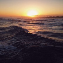 Sunset over waves in the ocean. 